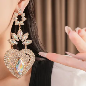 Detailed view of exaggerated heart-shaped earrings with iridescent marquise rhinestones.