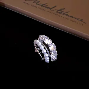 Detailed close-up of a silver ear cuff featuring white pearls and sparkling zircons