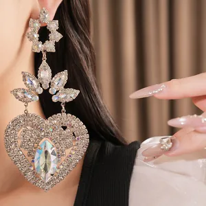 Detailed view of oversized heart rhinestone earrings in palace style with silver finish