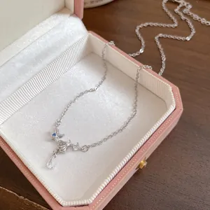 Close-up detail of silver starfish and shell necklace with blue zircon in a pink jewelry box
