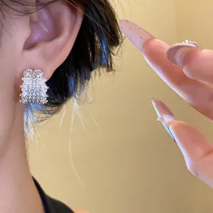 Detailed close-up view of a silver-toned C-shaped earring paved with sparkling cubic zirconia