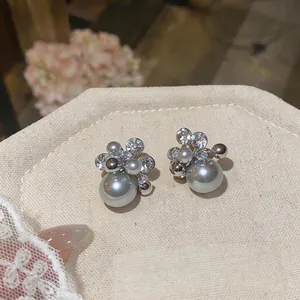 Close-up macro view of elegant gray pearl and cubic zirconia cluster floral stud earrings.
