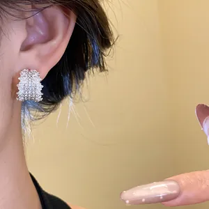 Side view detail of a silver C-shaped earring pavé-set with brilliant sparkling rhinestones