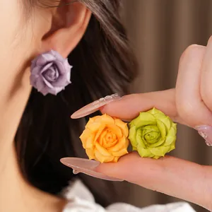 Detailed macro view of 18K gold plated rose flower stud earrings in multiple colors