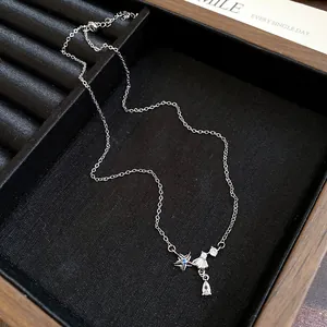 Detailed view of silver zircon necklace with star and teardrop charms on jewelry tray