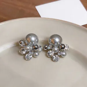 Close-up of elegant grey pearl and zircon cluster stud earrings in silver