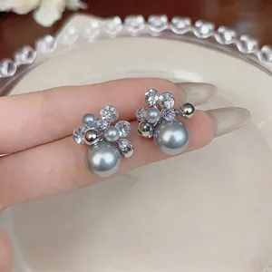 Detail of elegant grey pearl earrings with sparkling zircon stones on a silver-tone base.