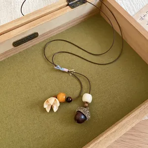 Retro Zen-style acorn pendant necklace with woven cord and floral charm decoration