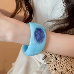 Detail of blue resin bangle with swirl texture and dark blue oval inlay