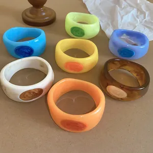 Detailed view of colorful resin bangles with marbled texture and oil drip design