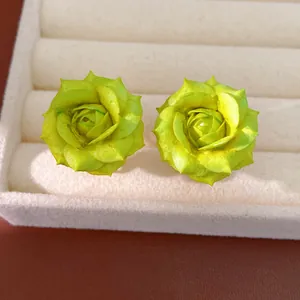 Macro detail of elegant lime green rose flower stud earrings with 18K gold plating finish