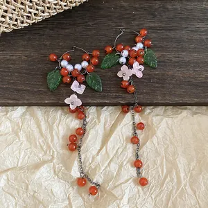 Detailed view of New Chinese style earrings with red berries, green leaves and flowers