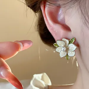 Close-up detail of an elegant French style enamel flower stud earring with a center pearl
