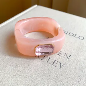 Detailed close-up of a pink marbled resin bracelet with lavender crystal inlay