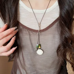 Close-up detail of a handmade acorn pendant necklace with Zen style braided cord on model