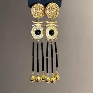 Elegant vintage gold-tone medallion drop earrings featuring black long tassels and beads