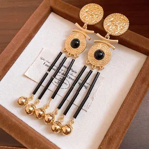 Elegant vintage style gold coin tassel earrings with black beads and Greek key pattern design