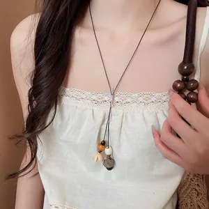 Elegant close-up of a New Chinese Zen-style acorn pendant necklace with wooden beads on a model.