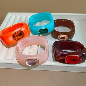 Close-up of colorful retro resin chunky bracelets featuring rectangular faceted crystal gems