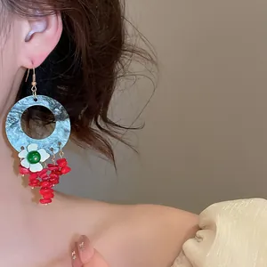 Close-up of retro Chinese style geometric flower tassel earrings on model