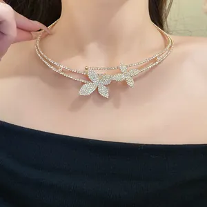 Dettaglio di un girocollo a doppio strato con fiori di strass scintillanti indossato dal modello.