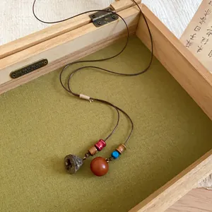 Detailed view of the Zen style necklace featuring a natural acorn pendant and colorful beads