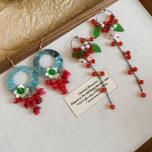 Detailed view of vintage-style floral tassel earrings in a wooden display tray.