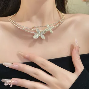 Dettaglio del girocollo a doppio strato con farfalla e strass di lusso sul collo della modella.