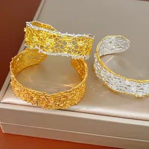 Close-up of delicate French retro lace hollow cuff bracelets with gold and silver finishes.