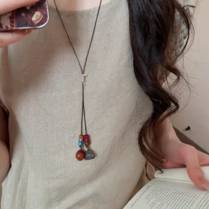 Close-up of a Zen-style acorn pendant necklace with wooden beads and woven cord.