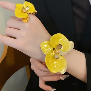 Parure di gioielli retrò con fiori in smalto giallo, bracciale e anello abbinato.