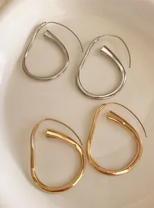 Primo piano di orecchini a cerchio geometrici irregolari in finitura oro e argento