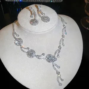 Nahaufnahme eines eleganten silberfarbenen Blumen- und Strass-Halsketten- und Ohrring-Sets