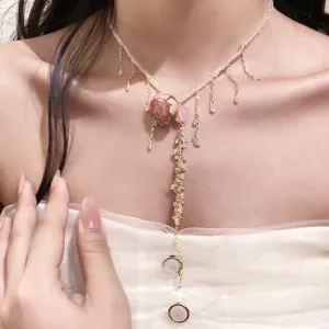 Close-up of an elegant pink rose floral necklace with delicate beads and hanging tassels