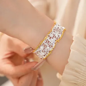Close-up view of elegant French retro hollow lace bracelet in two-tone gold and silver