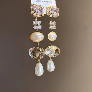 Detailed view of long tassel earrings with sparkling crystals and elegant white pearls