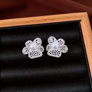 Vue détaillée de boucles d'oreilles fleurs évidées en argent avec perle centrale élégante