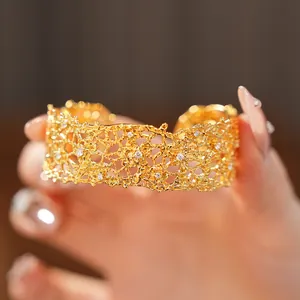 Detailed view of a French vintage lace hollow cuff bracelet in gold with small crystals