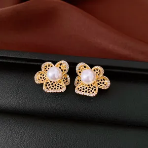 Gros plan détaillé de boucles d'oreilles pétales dorés avec perles et zircons scintillants