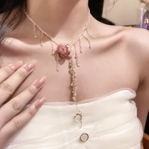 Detailed view of an elegant pink rose necklace with beaded chain and gold tassels