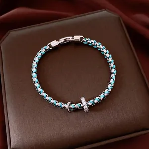 Elegant turquoise braided bracelet with silver-tone chain and rhinestone charms