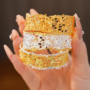 Close-up of gold and silver lace edge openwork bangles with sparkling crystals.