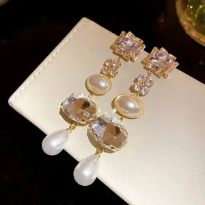 Detailed view of elegant square and oval pearl tassel earrings with diamond accents