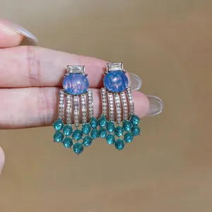 Vintage court-style resin earrings with green beaded tassels and elegant blue stone details.