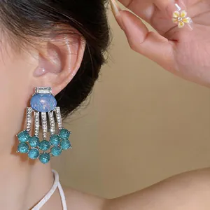 Detailed macro view of vintage court style resin tassel earrings featuring blue beads