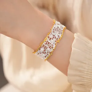 Detailed close-up of an elegant lace openwork bangle featuring a golden trim design