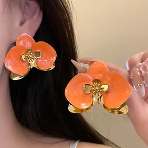 Vista dettagliata di orecchini a fiore in smalto arancione con una texture elegante