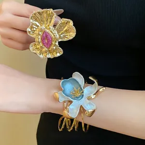 Vintage palace style pleated flower open bangle with rhinestone accents and enamel finish.