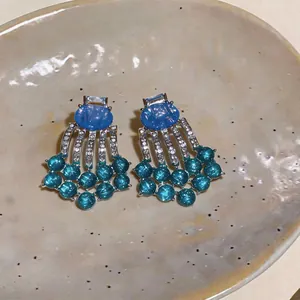 Macro view showing the intricate detail of vintage palace style blue resin tassel earrings