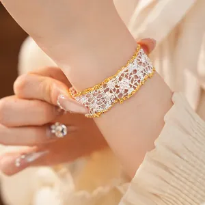 Close-up of elegant French retro lace openwork bracelet in two-tone gold and silver.